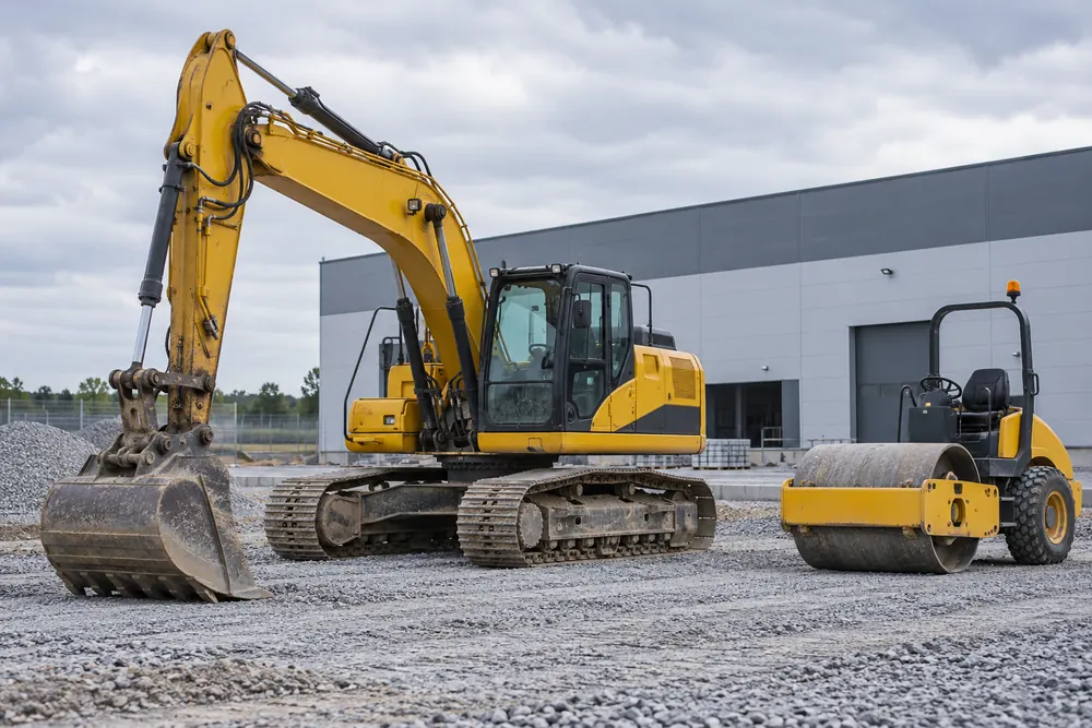 Excavator and roller at an industrial construction site